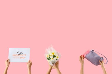 Bir buket lale, şenlikli kartpostal ve pembe arka planda el çantası olan kadın elleri. Uluslararası Kadınlar Günü kutlamaları