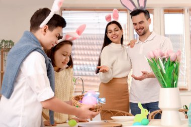 Mutlu ebeveynler ve küçük çocukları Paskalya Günü yemek odasında.