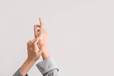 Ellerine krem süren kadın arka planda ışığa karşı, yakın plan