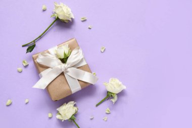 Leylak arka planında beyaz güller olan hediye kutusu