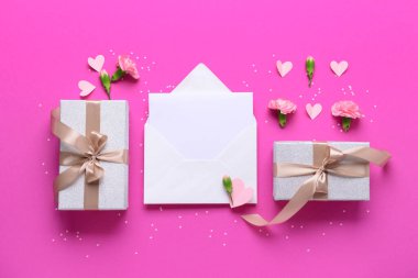 İçinde boş kart, hediye kutuları ve pembe arka planda karanfil çiçekleri olan bir zarf. Uluslararası Kadınlar Günü kutlamaları