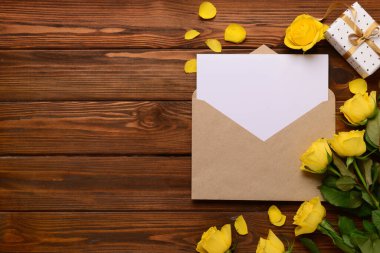 İçinde boş kart, hediye kutusu ve tahta arka planda gül çiçekleri olan bir zarf. Uluslararası Kadınlar Günü kutlamaları