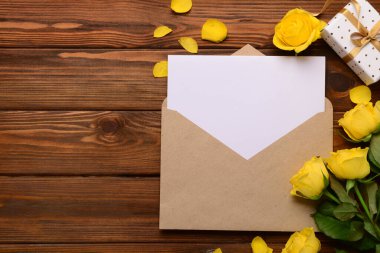 İçinde boş kart, hediye kutusu ve tahta arka planda gül çiçekleri olan bir zarf. Uluslararası Kadınlar Günü kutlamaları