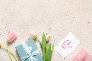 Mesajlı kart Mutlu Anneler Günü, hediye kutuları ve açık arkaplanda lale çiçekleri