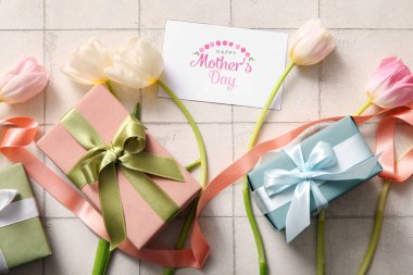 Mesajlı kart Mutlu Anneler Günü, hediye kutuları ve açık fayanslı lale çiçekleri