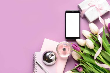 Modern cep telefonlu kompozisyon, güzel lale çiçekleri, parfüm ve renk arkaplanlı hediye kutusu