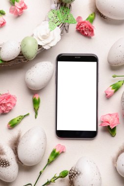 Modern cep telefonlu kompozisyon, Paskalya yumurtaları ve hafif arka planda çiçekler