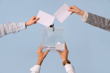 El, oy pusulasını arka plandaki sandığa koyuyor. Seçim kavramı