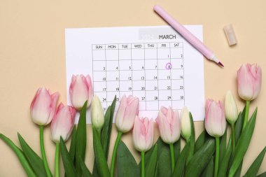 Açık sarı zemin üzerinde laleler olan bir takvim. Kadınlar Günü kutlaması