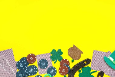 Sarı arka planda Aziz Patrick Günü kutlamaları için kart ve süslemeli poker fişleri