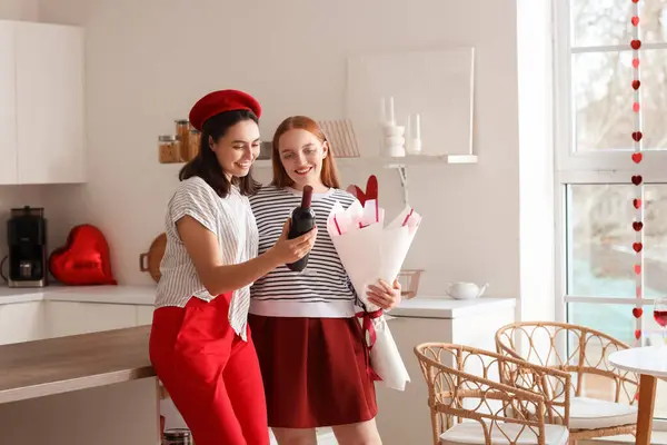 Sevgililer Günü 'nde mutfakta şarap ve çiçeklerle genç lezbiyen çift