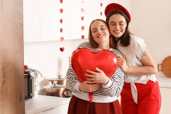 Sevgililer Günü 'nde mutfakta kalp şeklinde balonları olan genç lezbiyen çift.