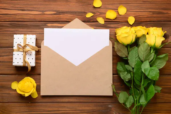 İçinde boş kart, hediye kutusu ve tahta arka planda gül çiçekleri olan bir zarf. Uluslararası Kadınlar Günü kutlamaları