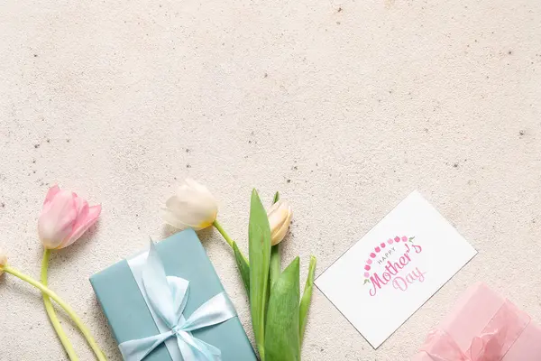 Mesajlı kart Mutlu Anneler Günü, hediye kutuları ve açık arkaplanda lale çiçekleri