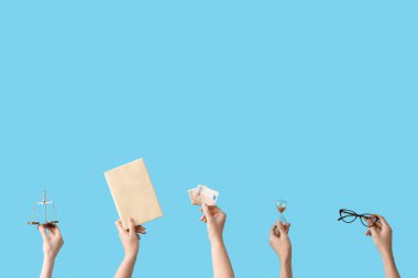 Kum saati tutan kadın elleri, adalet terazisi, mavi arka planda kitap ve para