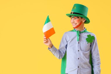 Yüz boyama, İrlanda bayrağı ve sarı arka planda cüce şapkası olan komik çocuk. Aziz Patrick Günü kutlaması