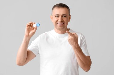 Kontak lensi ve gri arkaplanı olan olgun bir adam