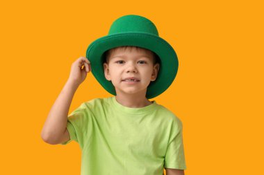 Sarı arka planda cüce şapkalı şirin bir çocuk. Aziz Patrick Günü kutlaması
