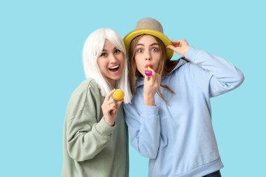 Mavi arka planda komik kılık değiştirmiş güzel genç kadınlar. 1 Nisan şakası