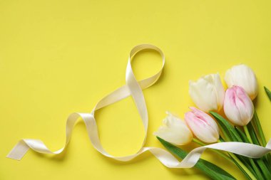 8 numaralı figür şeritten yapılmış kompozisyon ve sarı arka planda çiçekler. Uluslararası Kadınlar Günü kutlamaları