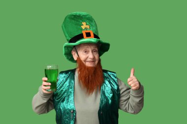 Kırmızı sakallı, kırmızı sakallı, cüce şapkalı yaşlı kadın elinde bir bardak bira ve yeşil arka planda baş parmak hareketi gösteriyor. Aziz Patrick Günü kutlaması