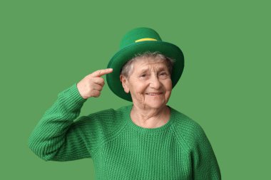 Yeşil arka plandaki cüce şapkayı gösteren yaşlı kadın. Aziz Patrick Günü kutlaması