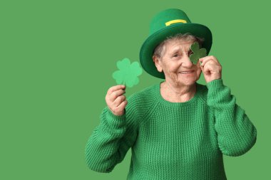 Yeşil arka planda yonca olan cüce şapkalı yaşlı kadın. Aziz Patrick Günü kutlaması