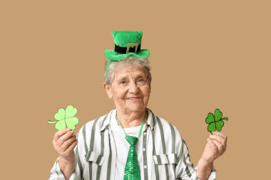 Kahverengi arka planda yonca olan cüce şapkalı yaşlı kadın. Aziz Patrick Günü kutlaması
