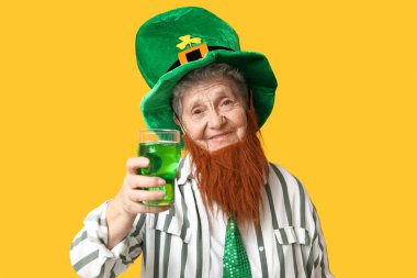 Leprikon şapkalı, kırmızı sakallı, sarı arka planda bira bardağı tutan yaşlı kadın. Aziz Patrick Günü kutlaması