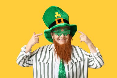 Leprikon şapkalı yaşlı kadın ve sarı arka planda kırmızı sakallı dekoratif gözlüklü. Aziz Patrick Günü kutlaması
