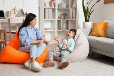 Kadın psikolog ofiste küçük bir çocukla konuşuyor.