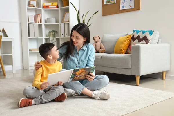 Ofiste kitap okuyan küçük bir çocukla kadın psikolog.