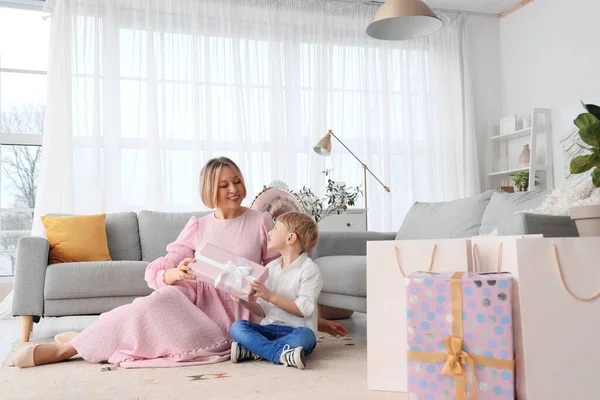 Küçük çocuk evde annesine hediyeyle selam veriyor. Uluslararası Kadınlar Günü