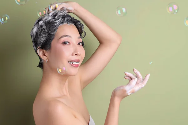 Молодая Азиатка Применяет Шампунь Мыльные Пузыри Зеленом Фоне Крупным Планом — стоковое фото