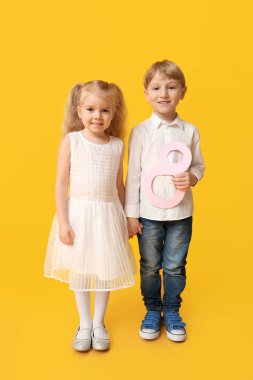 Sarı arka planda kağıttan yapılmış 8 figürlü şirin çocuklar. Uluslararası Kadınlar Günü