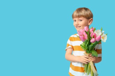 Mavi arka planda bir buket güzel lalesi olan sevimli küçük bir çocuk. Uluslararası Kadınlar Günü