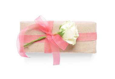 Pembe fiyonklu hediye kutusu ve beyaz arka planda güzel bir gül. Uluslararası Kadınlar Günü