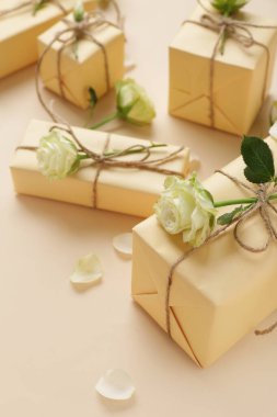 İçinde güzel beyaz güller ve bej arka planda taç yaprakları olan hediye kutuları. Uluslararası Kadınlar Günü
