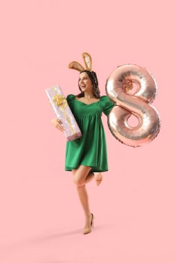 Pembe arka planda hediye ve balon şeklinde 8 figürlü güzel bir kadın. Uluslararası Kadınlar Günü