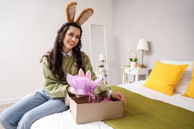 Evde paskalya pastası olan tavşan kulaklı genç kadın.