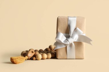 Bej arka planda Ramazan için dua boncukları olan hediye kutusu