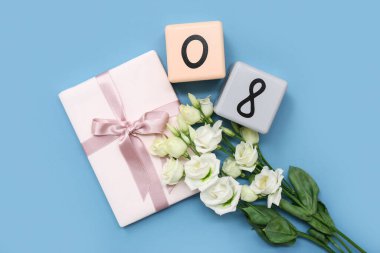 Küp takvimi, tarih 08, hediye kutusu ve mavi arka planda güzel Eustoma çiçekleri. Uluslararası Kadınlar Günü