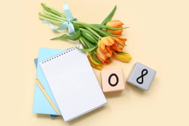 Küp takvimi, tarih 08, bir buket güzel lale ve sarı arka planda not defterleri. Uluslararası Kadınlar Günü