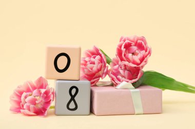 Küp takvimi, tarih 08, güzel laleler ve sarı arka planda hediye kutusu. Uluslararası Kadınlar Günü