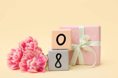 Küp takvimi, tarih 08, güzel laleler ve sarı arka planda hediye kutusu. Uluslararası Kadınlar Günü
