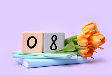 Küp takvimi, tarih 08, güzel turuncu laleler ve eflatun arkaplan üzerine not defterleri. Uluslararası Kadınlar Günü