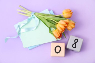 Küp takvimi, tarih 08, güzel turuncu laleler ve eflatun arkaplan üzerine not defterleri. Uluslararası Kadınlar Günü