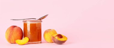 Pembe arkaplanda tatlı şeftali reçelli kavanoz ve metin için boşluk