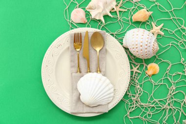 Yeşil arka planda deniz dekoruyla servis edilen güzel bir masa.