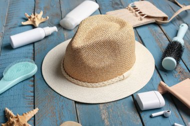 Farklı plaj aksesuarları, kulaklıklar ve ahşap arka planda saç fırçaları olan kompozisyon